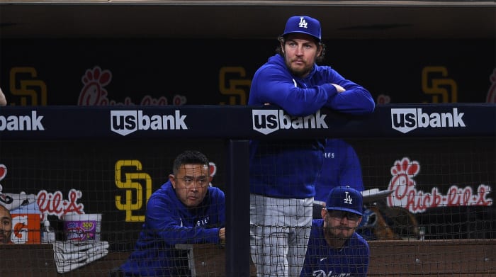 Jun 22, 2021; San Diego, California, USA; Los Angeles Dodgers starting pitcher Trevor Bauer (top) looks on from the dugout during the fifth inning against the San Diego Padres at Petco Park.
